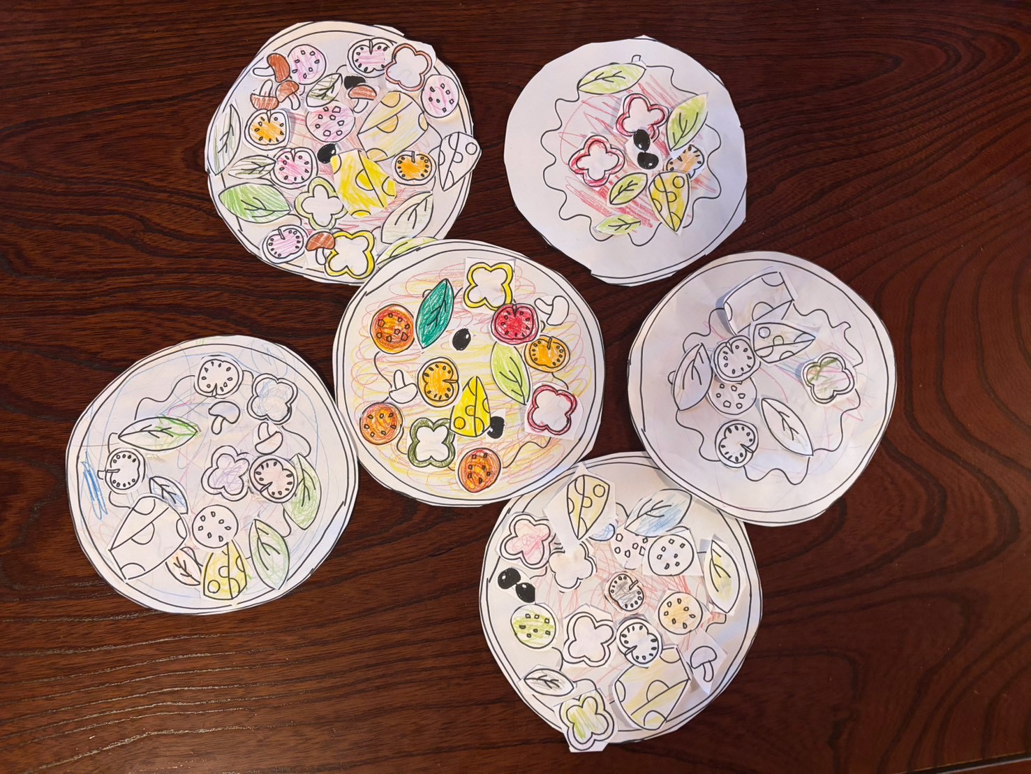 レッスンで色を塗って作った、子どもたちのピザの作品